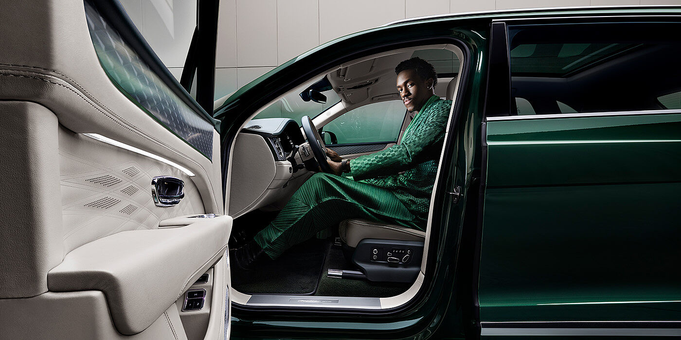 Bentley Düsseldorf Wisdom K seated in Bentley Bentayga Extended Wheelbase SUV in Light Emerald green paint with door open