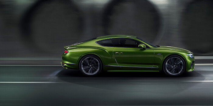  Bentley Düsseldorf Bentley Continental GT coupe in Tourmaline Green paint driving in profile on a dark road