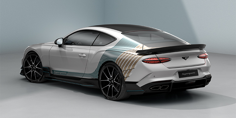 Bentley Düsseldorf Bentley Supersports rear three quarter in "Snowstorm" Design theme with Snow Quartz paint and Topaz blue and Camel brown paint stripes across the rear haunch.